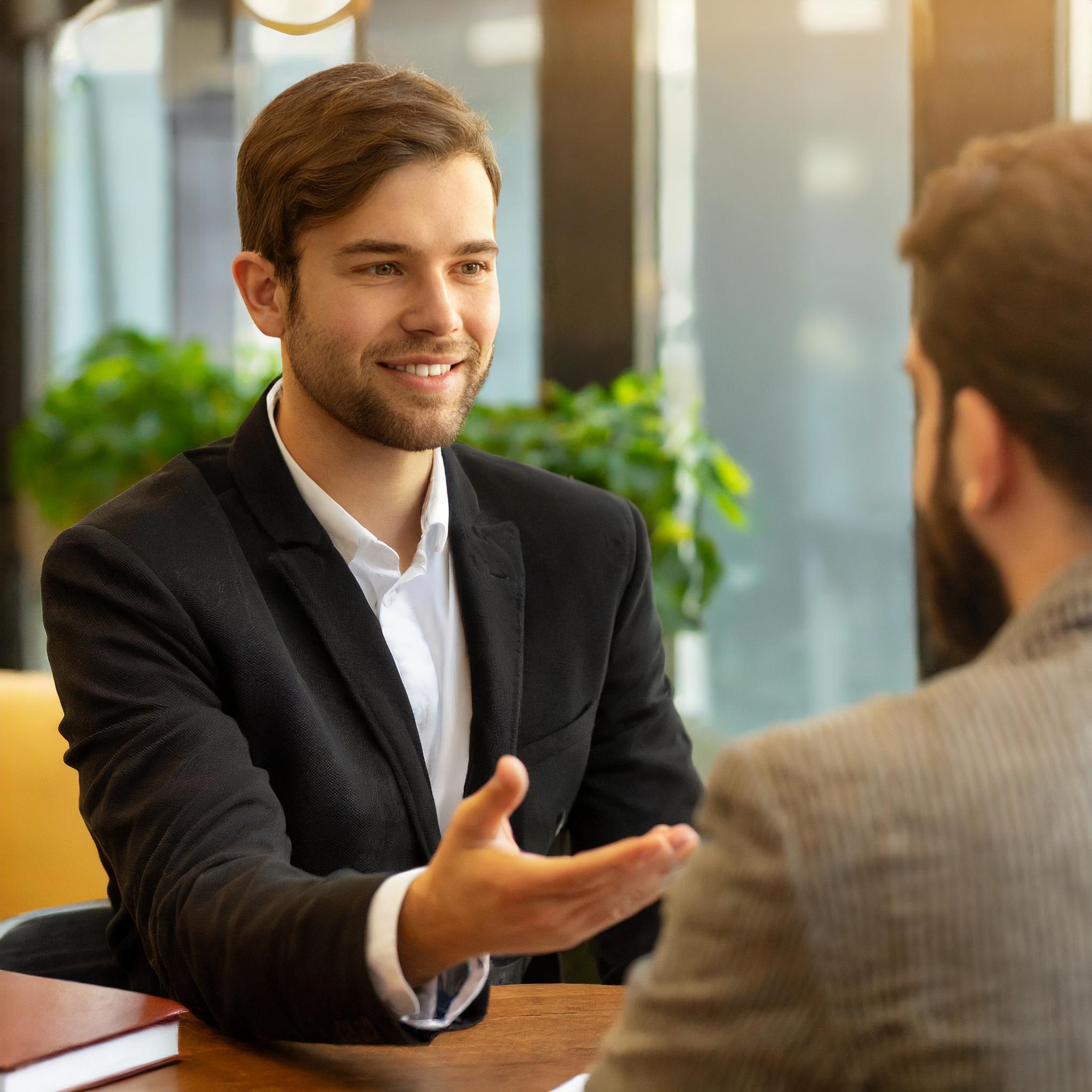 Sozialberatungsgespräch zwischen Berater und Klient in einem einladenden Büro